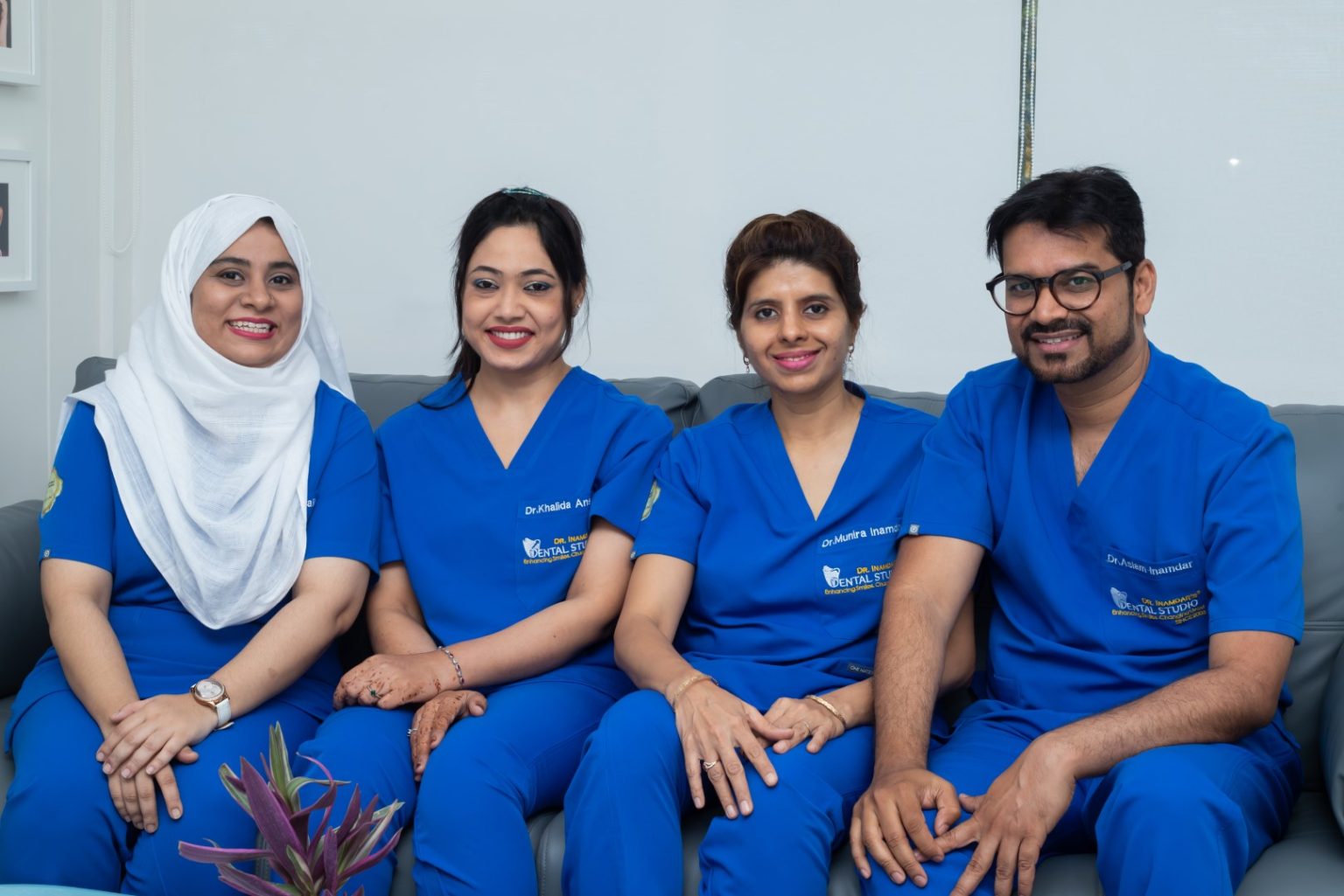 Four dentists sitting together on a sofa