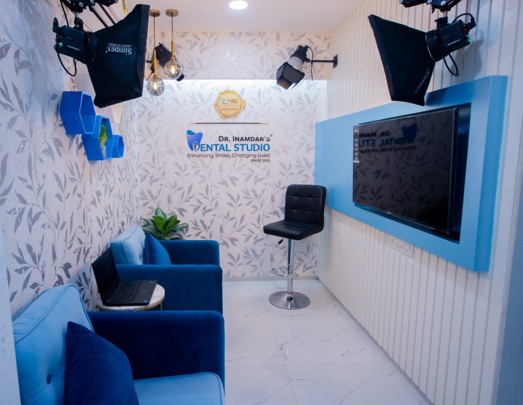 A room featuring blue chairs arranged around a television on the wall.