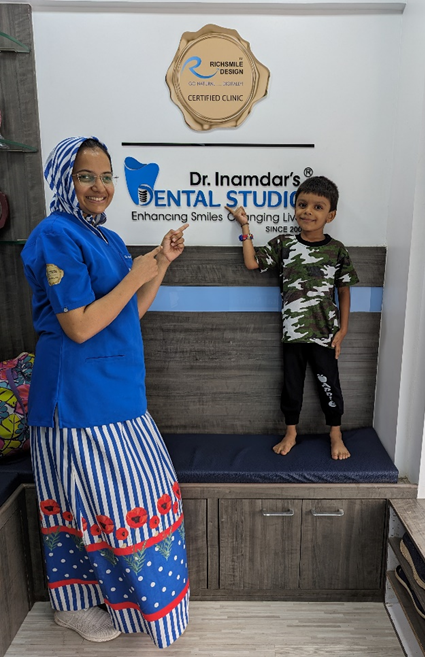 A woman and a child standing and pointing their hands toward the IDS logo