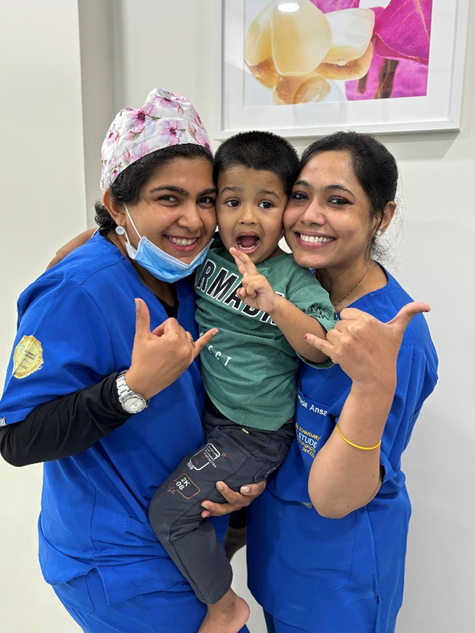 Two dentists and a child posing for a picture